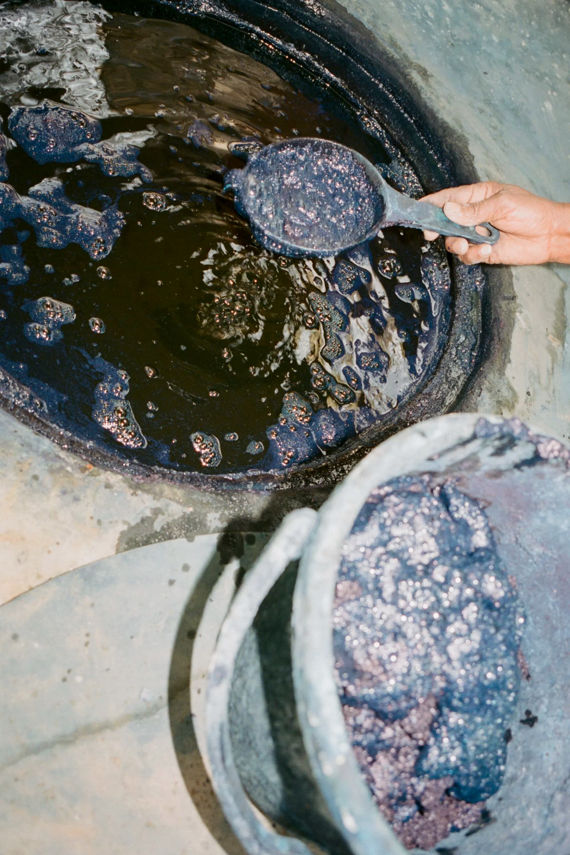 Skimming indigo vat with ladle