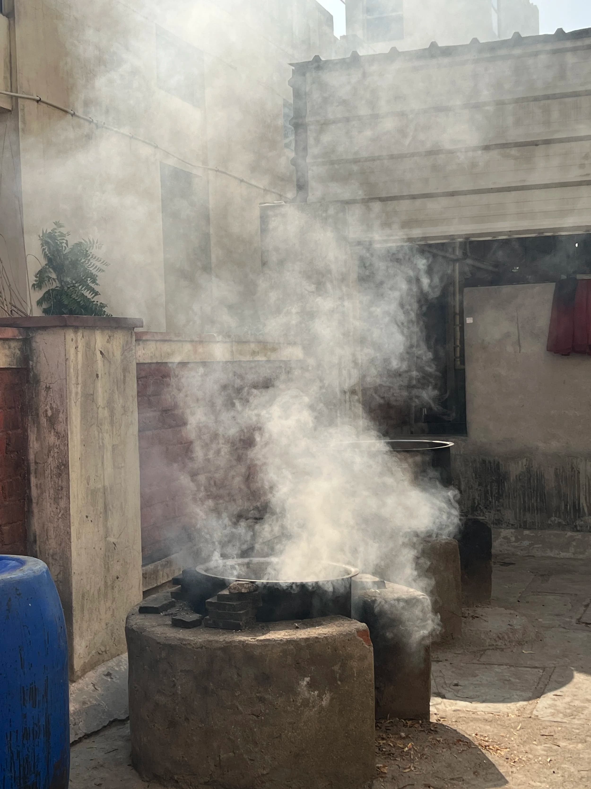 Steam rising from indigo vat in courtyard